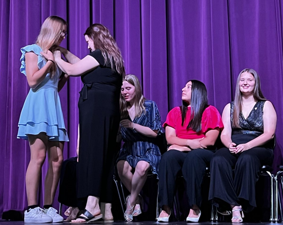 NHS adviser Lauren Rodriguez pins new inductee Genevieve Arabie. Rodriguez and teacher Donna Vann head up the National Honor Society; the group is planning several joint events with Student Council this year.