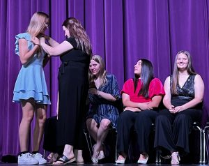 NHS adviser Lauren Rodriguez pins new inductee Genevieve Arabie. Rodriguez and teacher Donna Vann head up the National Honor Society; the group is planning several joint events with Student Council this year.