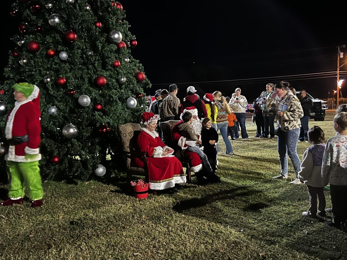 Santa and Mrs. Claus visit with the children lined up at the community tree. 