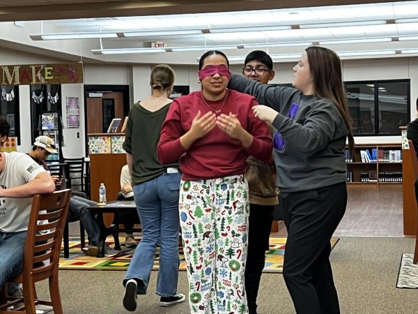 NHS and StuCo adviser Lauren Rodriguez helps senior Oswaldo Garcia blindfold his partner, junior Alexa Sanchez, for one of the games. Students earned tickets to draw for prizes.