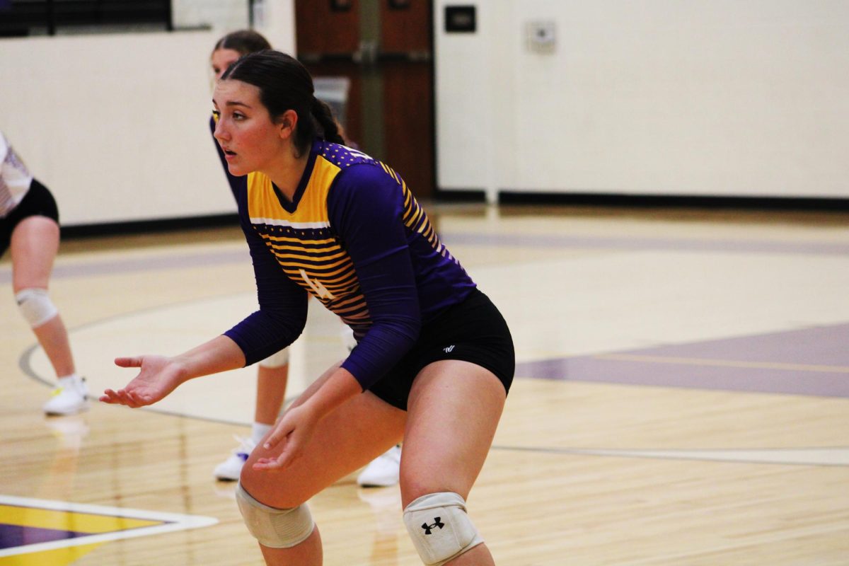 Junior Evangeline Arabie gets ready to receive a serve during a home volleyball game.