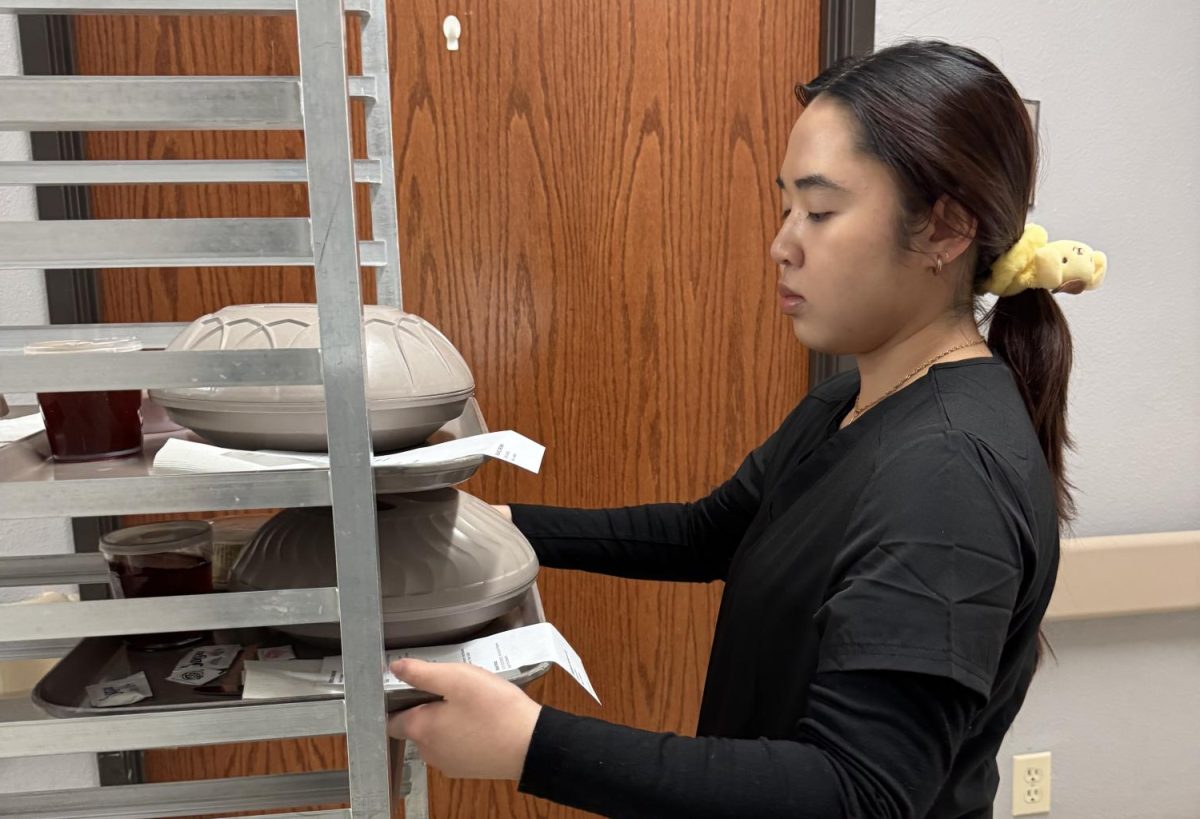 Senior Sharlene Le hands out lunch trays to residents at the Fairfield Nursing Home during clinicals. Students will take their certification exams this spring. 